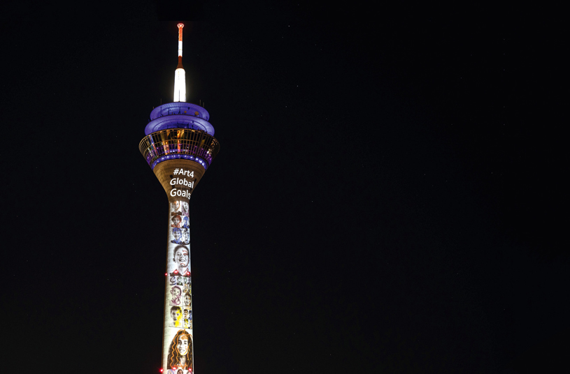   Die Nachhaltigkeitsziele der UN, die Sustainable Development Goals (SDGs), bieten auch Stoff für Künstler – so etwa im März dieses Jahres in Düsseldorf. Der 240,5 Meter hohe Rheinturm wurde mit einer Collage aus Werken des jungen Kunststars Leon Löwentraut illuminiert. Eine künstlerische Interpretation der SDGs, die für Aufsehen sorgte. © picture alliance/dpa/ Marius Becker